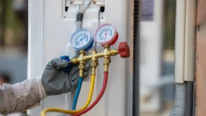 Skilled technician adding R-410A refrigerant with a gauge to a cooling system for efficient cooling.